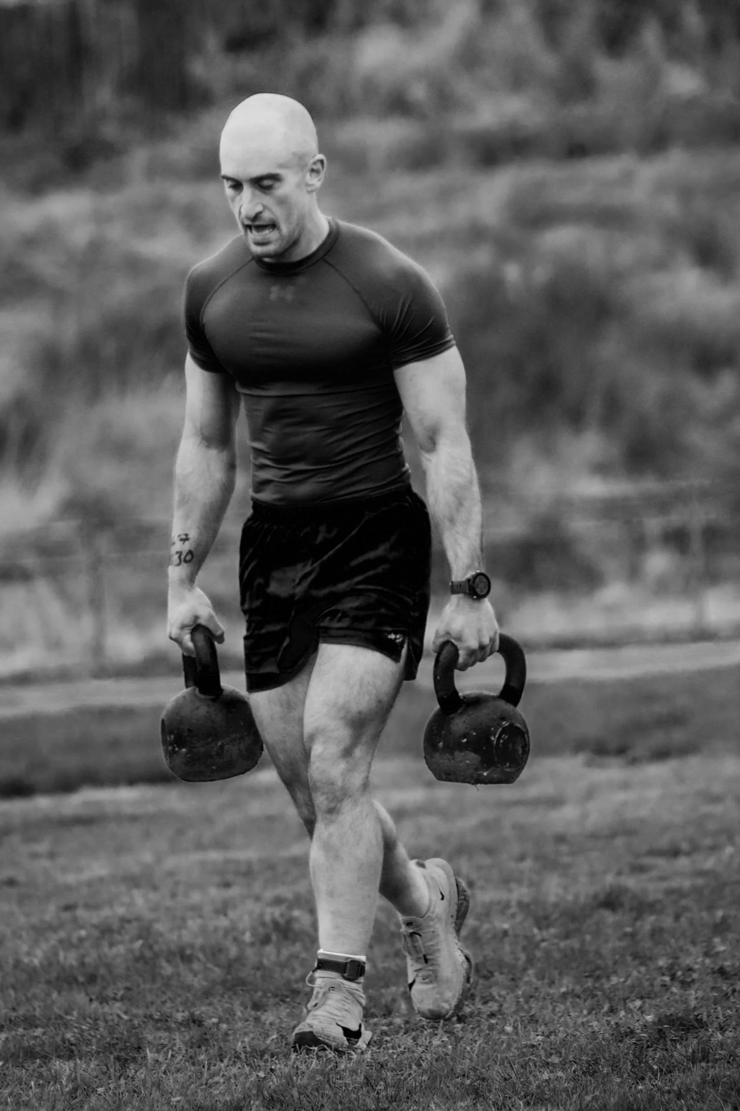 Atleta che trasporta due kettlebell lungo la corsia di 30 metri nella prova "Farmers Carry Labour"